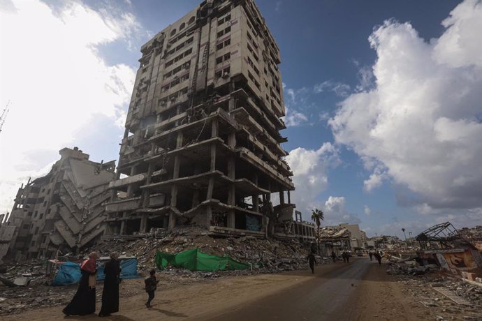 February 5, 2025, Gaza City, Gaza Strip, Palestinian Territory: Palestinians walk past collapsed buildings along the streets of Gaza City on February 5, 2025, during a ceasefire agreement in the war between Israel and Hamas. The Palestinian militant group