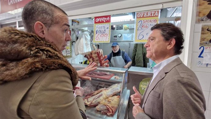 El delegado territorial de Empleo, Empresa y Trabajo Autónomo de la Junta en la provincia de Cádiz, Daniel Sánchez Román, y el concejal responsable de Comercio en el Ayuntamiento de El Puerto, David Calleja, en un puesto del mercado.