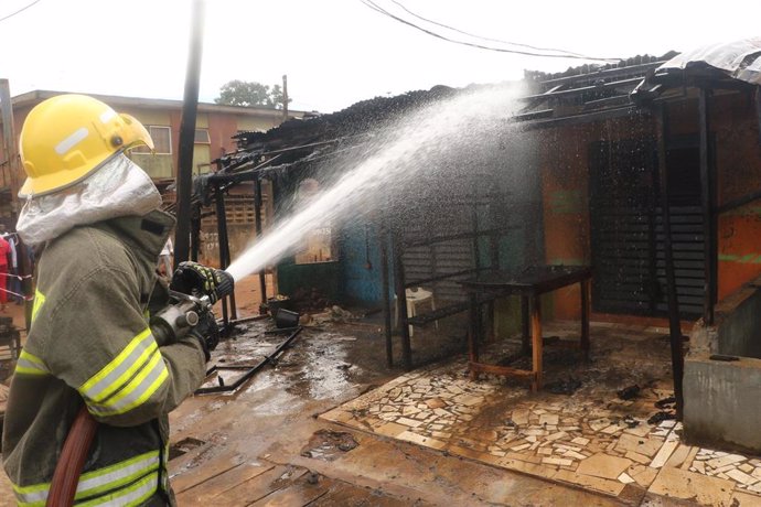 Archivo - Imagen de archivo de un bombero extinguiendo un incendio en Nigeria