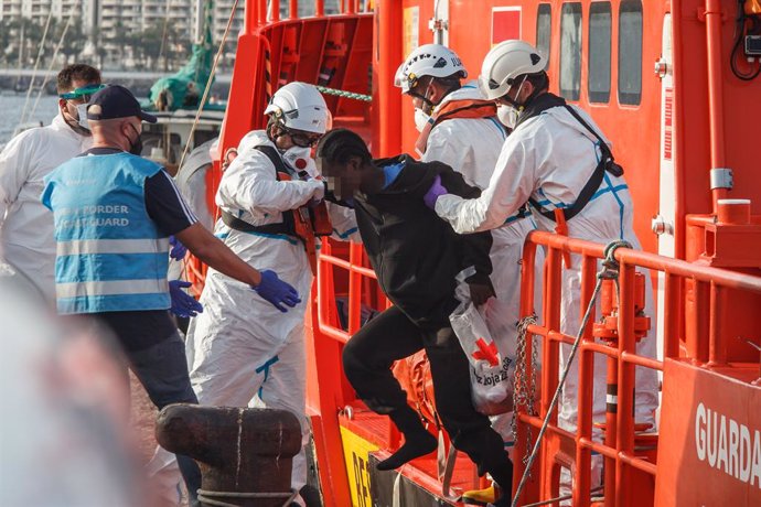 Archivo - Varios trabajadores ayudan a una mujer a salir de la embarcación de Salvamento Marítimo ‘Guardamar Talía’ a su llegada al muelle de Arguineguín con varias decenas de migrantes, a 28 de agosto de 2021, en Arguineguín, Mogán, Gran Canaria, (España