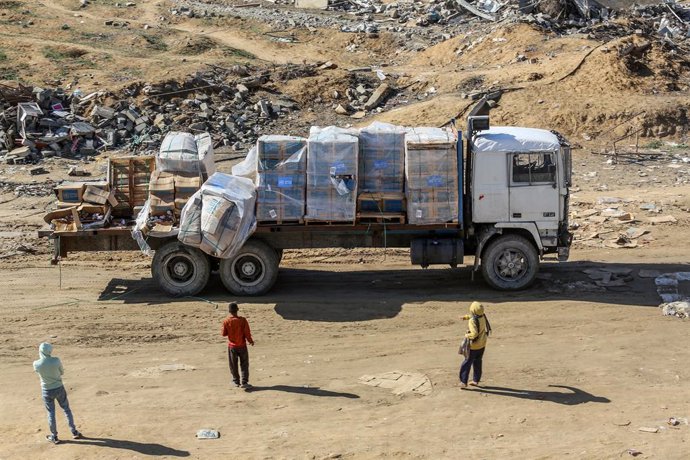 23 January 2025, Palestinian Territories, Rafah: Humanitarian aid from the United Nations Relief and Works Agency for Palestine Refugees in the Near East (UNRWA) falls from a truck as it enters through the Kerem Shalom crossing from Egypt into the Gaza St