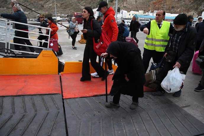 Un grupo de personas embarca en un ferry para salir de la isla de Santorini