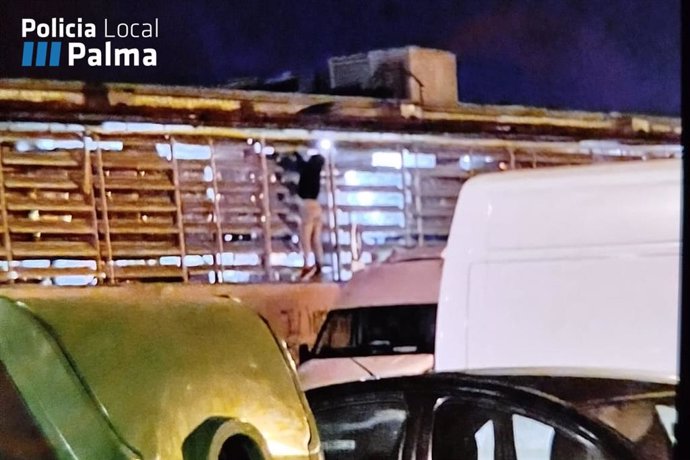 El joven trepando por el muro del centro comercial de Cas Capiscol.