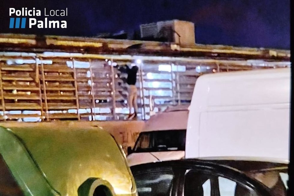 El joven trepando por el muro del centro comercial de Cas Capiscol.