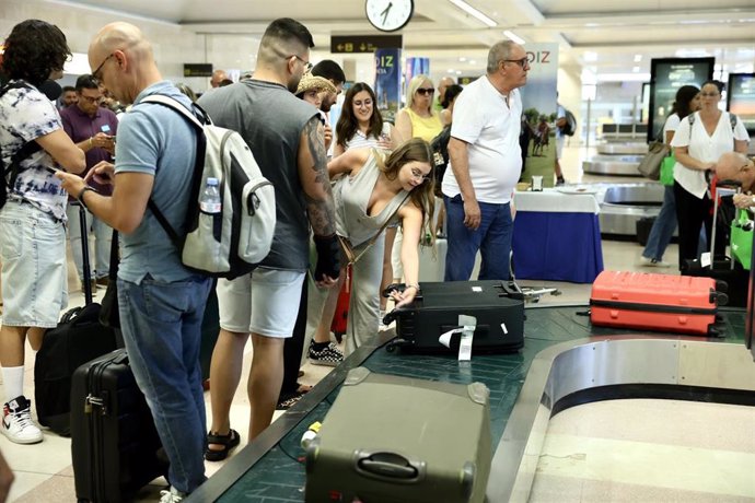 Archivo - Pasajeros recogiendo sus malestas en el aeropuerto de Jerez