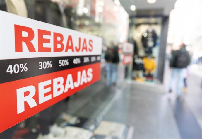 Archivo - Carteles en un escaparate anuncian la temporada de rebajas.