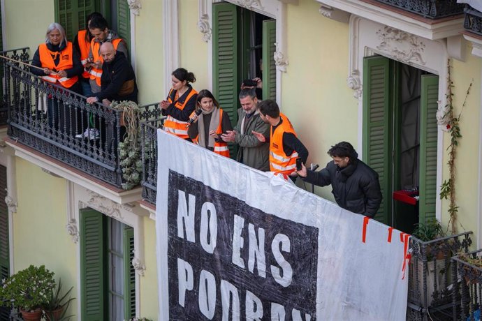 La activista del Sindicato de Inquilinos de Cataluña Carme Arcarazo (2i) y Josep (c), el vecino afectado por el desahucio observan desde su balcón la concentración de Sindicat de Llogateres de Catalunya y vecinos en contra del desalojo de la Casa Orsola