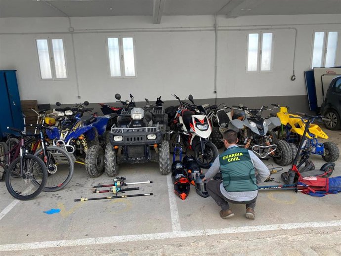 Un agente de la Guardia Civil junto a motos y quads en garajes comunitarios.
