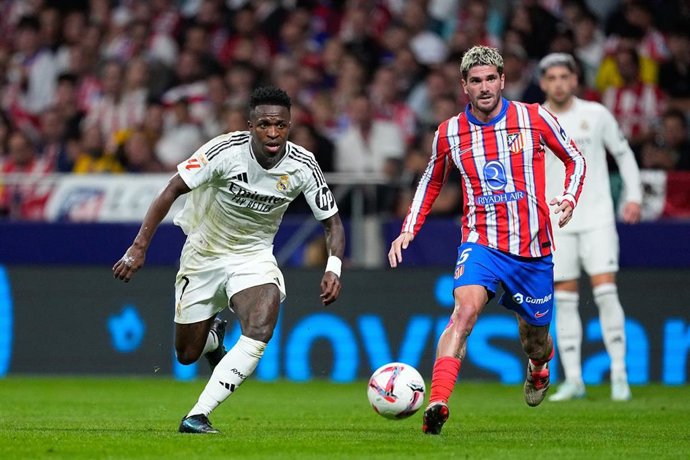 Archivo - El jugador del Real Madrid Vinícius Júnior regatea al centrocampista del Atlético de Madrid Rodrigo de Paul, en el Riyadh Air Metropolitano.