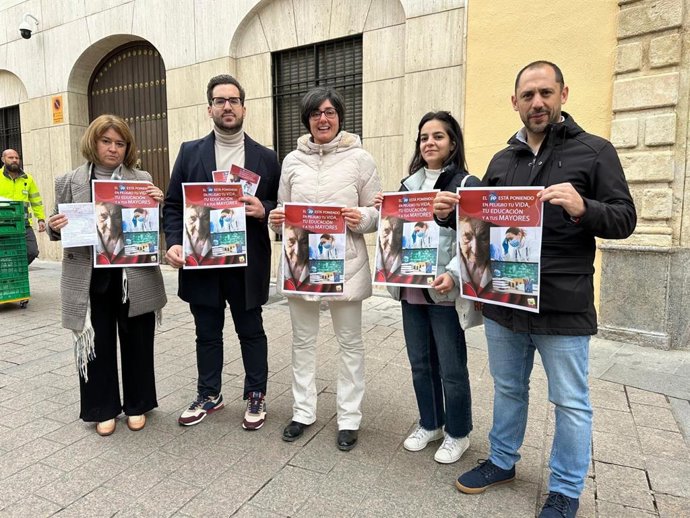 Carmen María Ruiz (centro), junto a otros dirigentes de IU Córdoba, muestra el cartel de la campaña, ante la Delegación del Gobierno andaluz en Córdoba.