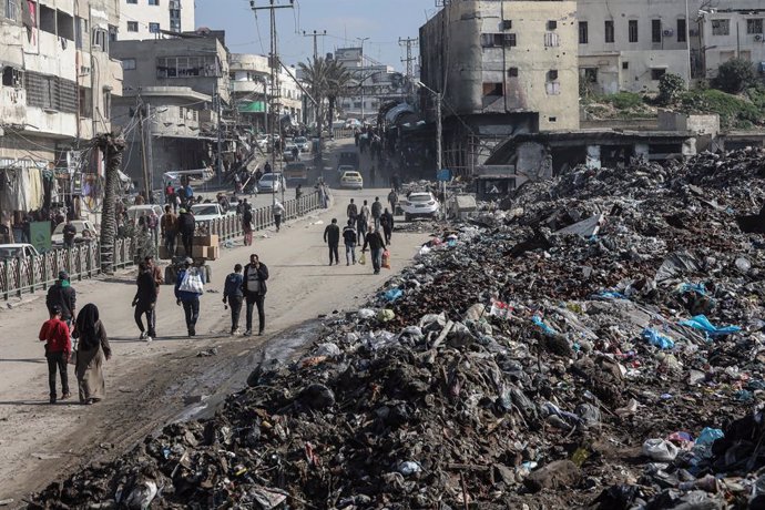 04 February 2025, Palestinian Territories, Gaza City: Palestinians walk next to a pile of garbage in Gaza City, amid the ceasefire between Israel and Hamas. Photo: Omar Ashtawy/APA Images via ZUMA Press Wire/dpa