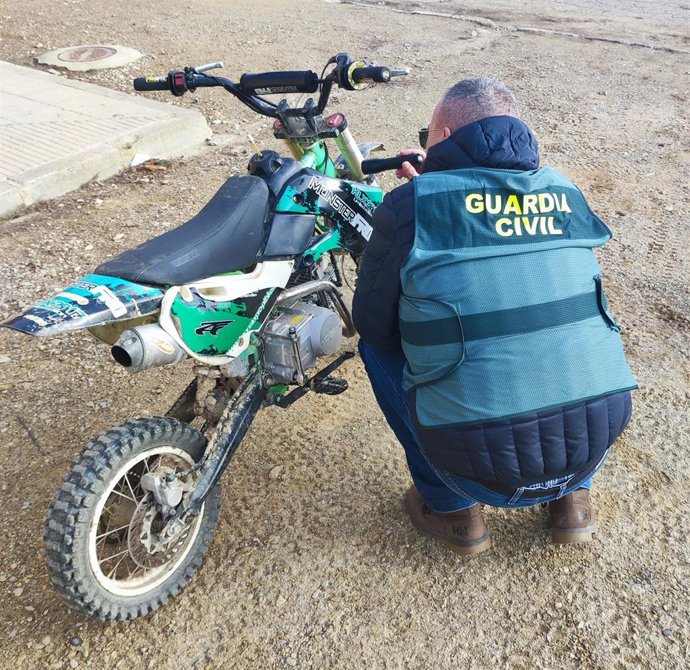 Un agente inspecciona la minimoto incautada.