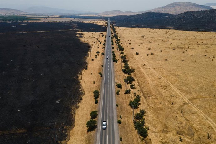 Archivo - December 26, 2024, Til Til, Santiago, Chile: Cars travel along a road that was left in the midst of a forest fire that affected the Til Til area, near Santiago, Chile.