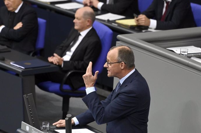 Friedrich Merz, en primer plano, con el canciller alemán, Olaf Scholz, en el fondo de la imagen 