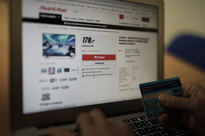Archivo - Una persona se dispone a pagar con su tarjeta de crédito una compra online.