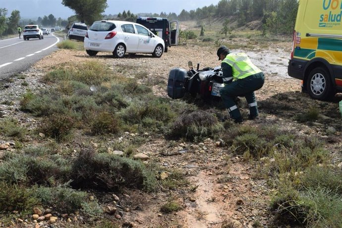 Un agente de la Guardia Civil examina la motocicleta con la que un motorista ha sufrido un acidente de tráfico este domingo en la TEV-1611 en Loscos (Teruel).