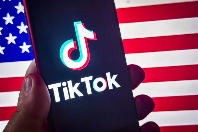 18 January 2025, US, ---: Social Media App TikTok logo Pictured on smart phone before the US flag.