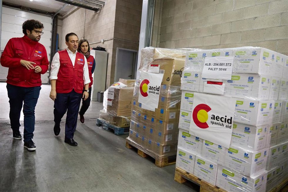 El ministro de Asuntos Exteriores, Unión Europea y Cooperación, José Manuel Albares (c), visita el almacén donde se encuentra las cajas con ayuda humanitaria destinada a Gaza, en el centro de carga aérea Madrid-Barajas
