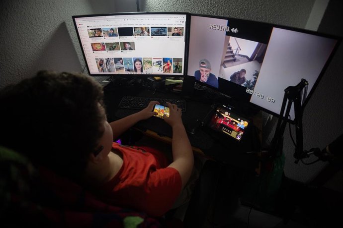 Un niño mientras observa varias pantallas