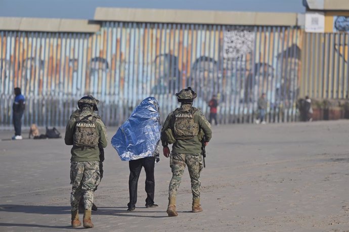 05 February 2025, Mexico, Tijuana: Mexican Marine troops guard a smuggler guiding migrants, who almost drowned before being rescued by Tijuana lifeguards near the US-Mexico beach border in Tijuana. Photo: Carlos A. Moreno/ZUMA Press Wire/dpa