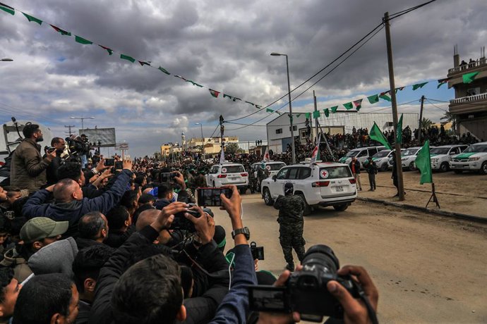 08 de fevereiro de 2025, Territórios Palestinos, Deir al-Balah: Reféns israelenses são entregues aos representantes do Comitê Internacional da Cruz Vermelha (CICV) por combatentes das brigadas Ezz al-Din Al-Qassam, a ala militar do Hamas, na quinta b