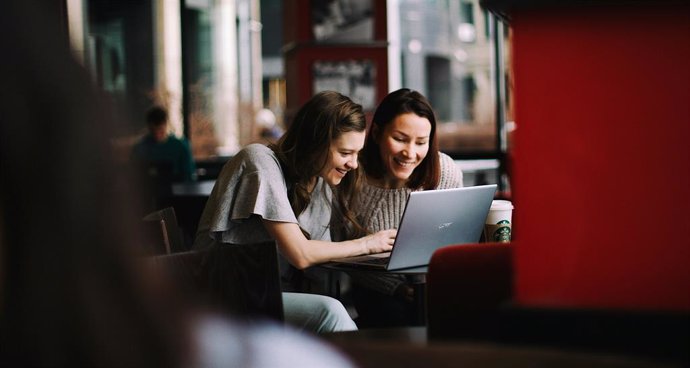 Dos mujeres mirando algo en la pantalla de un ordenador