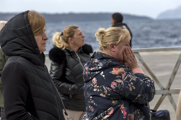 Un grupo de personas esperan para salir de la isla griega de Santorini