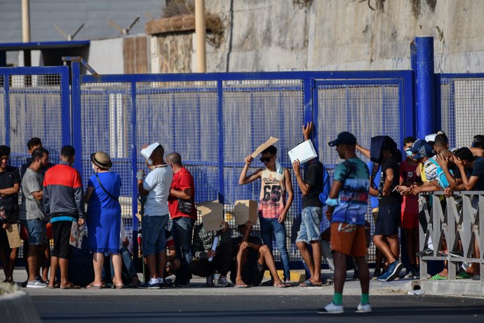 Archivo - Cientos de personas, la mayoría marroquíes, guardan cola en la oficina para tramitar los asilos situada en la frontera del Tarajal que separa Ceuta de Marruecos, a 3 de agosto de 2021, en Ceuta (España). A pesar de que 250 inmigrantes marroquíes