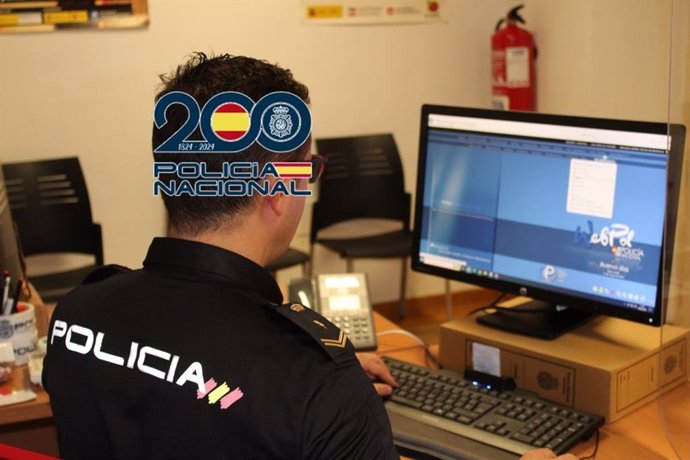 Archivo - Agente de la Policía Nacional junto a un ordenador.
