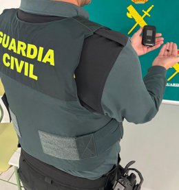 Agente da Guardia Civil de Menorca com o dispositivo apreendido de um candidato ao exame de direção.