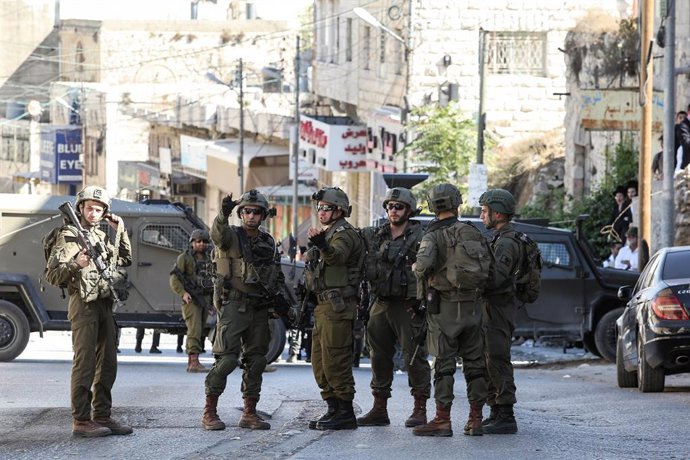 Archivo - 21 October 2024, Palestinian Territories, Hebron: Israeli soldiers stand at the Old City area of Hebron, as a group of Jewish settlers raid the area during the Jewish festival of Sukkot. Photo: Taha Abu Hussein/APA Images via ZUMA Press Wire/dpa