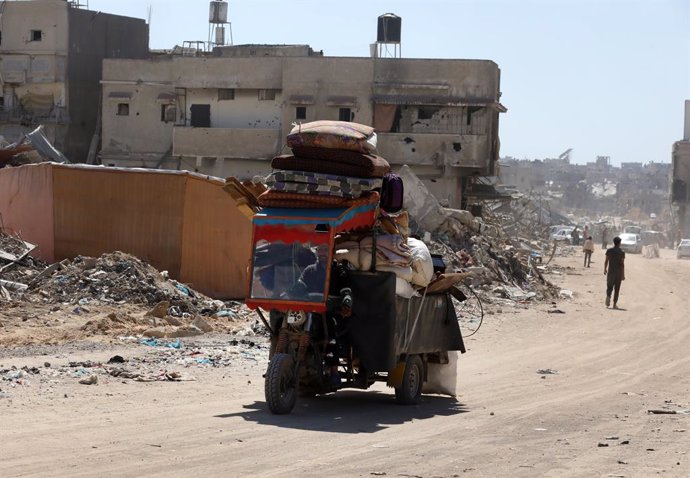 Archivo - Imagen de archivo de desplazados palestinos trasladando sus pertenencias entre las ruinas de sus viviendas después de que el Ejército israelí les pidiera evacuar la ciudad de Rafá