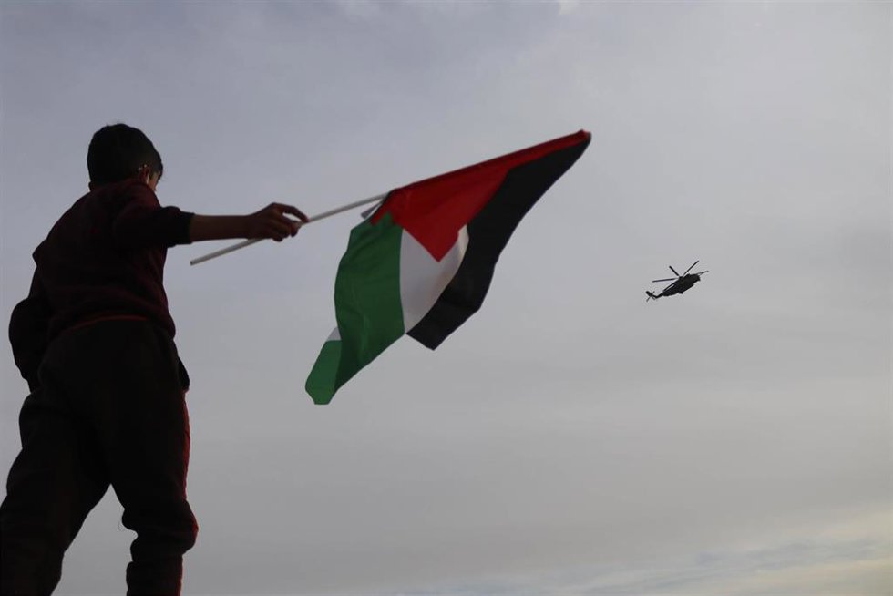 Archivo - Imagen de archivo de un niño ondeando una bandera palestina en Hebrón