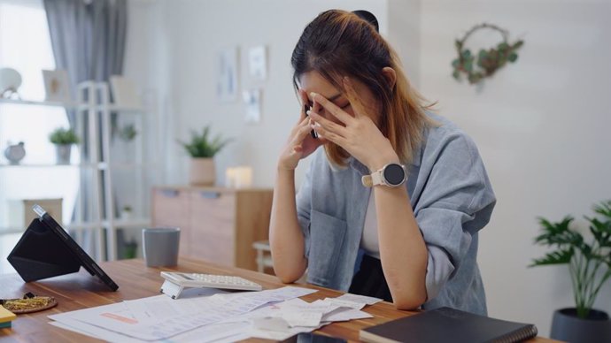 Archivo - Mujer tomando una decisión económica. Facturas, dinero, miedo