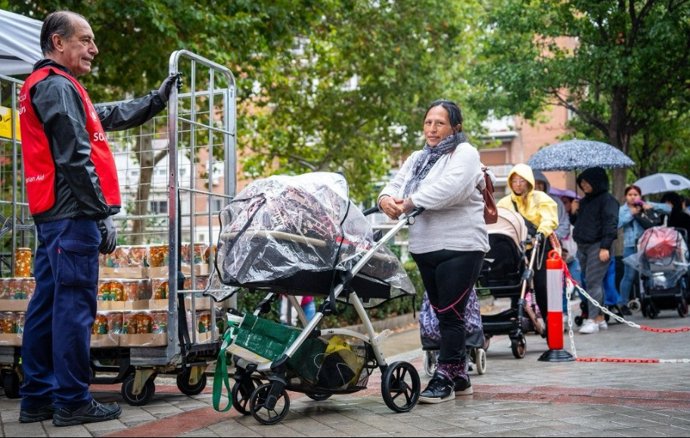 Varias mujeres hacen cola en la sede de Fundación Madrina.