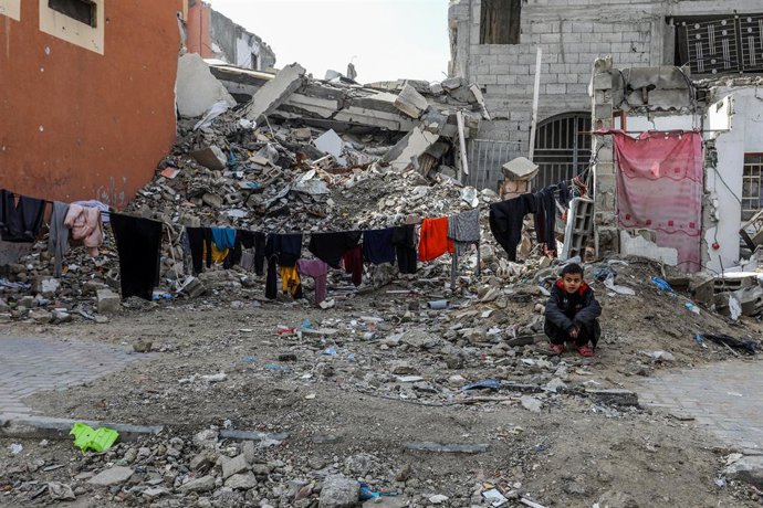 11 February 2025, Palestinian Territories, Khan Younis: A Palestinian child sits in front of a destroyed house in Khan Younis. Hamas spokesman Abu Obeida announced the indefinite postponement of the next set of Israeli hostage releases due to Israel's fai
