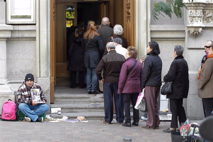 Archivo - Una persona pidiendo en la calle.