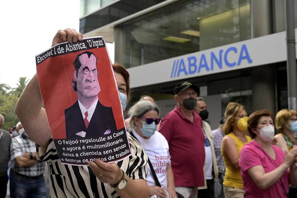 Archivo - Una persona sostiene una pancarta durante la manifestación contra el cierre de oficinas de la entidad Abanca ante la sede de Abanca en A Coruña, a 2 de septiembre de 2021, en A Coruña, Galicia, (España). El objetivo de la protesta, convocada p