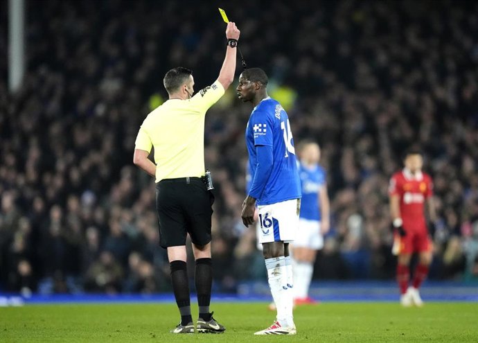 Michael Oliver amonesta a Abdoulaye Doucoure durante el Everton-Liverpool de la Premier League 24-25