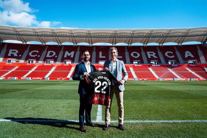 Alfonso Díaz, CEO de Negocio del RCD Mallorca, y Pablo Pardo, director general de NDL Pro-Health, posan con la camiseta del equipo bermellón y el dorsal 22, en homenaje a los 22 Grand Slams que Rafa Nadal