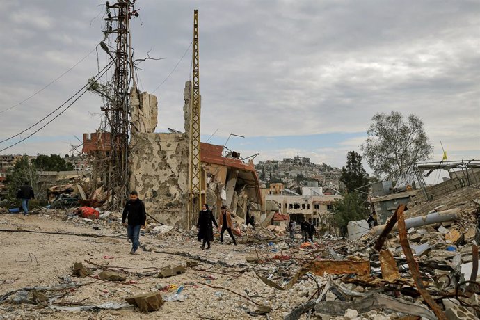 26 January 2025, Lebanon, Ayta ash-Shaab: Lebanese Muslim Shiites walk through wreckage of destroyed houses in southern Lebanese border village of Ayta ash-Shaab after returning to their devastated hamlet. Israeli troops opened fire on villagers returning