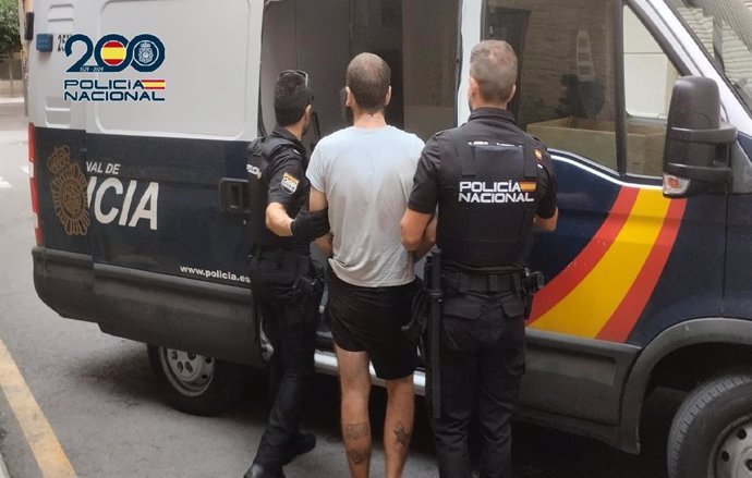 Uno de los detenidos es custodiado por dos agentes de la Policía Nacional