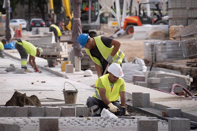 Archivo - Operarios trabajando en unas obras