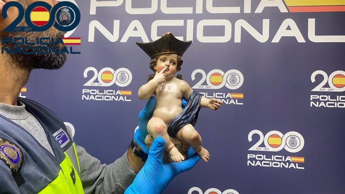 Un agente muestra la figura del angelito con birrete mandando silencio