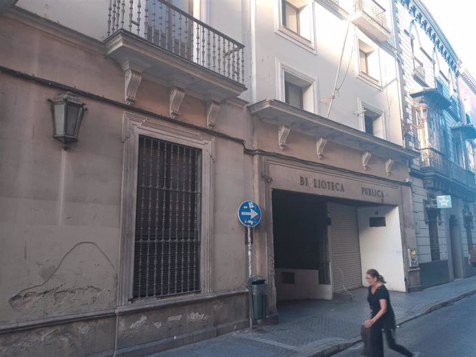 Archivo - Una mujer camina a escasos metros de la antigua biblioteca pública de Alfonso XII, junto al Palacio de Monsalves.