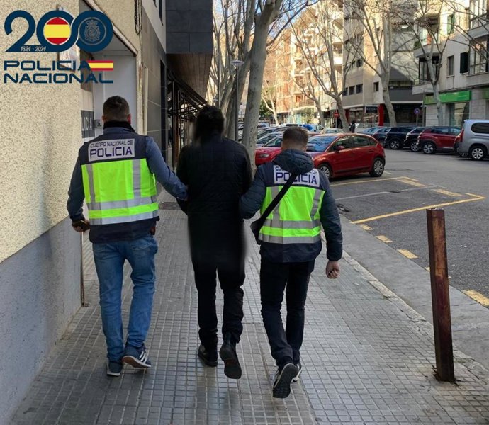 El detenido, conducido por dos agentes.