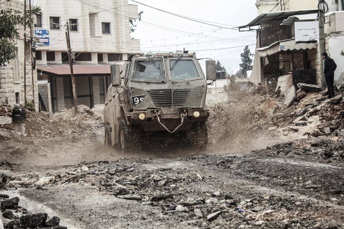 11 de fevereiro de 2025, Jenin, Cisjordânia, Palestina: Um veículo militar israelense passa pelo meio do mercado destruído no bairro oriental da cidade de Jenin, na Cisjordânia. A operação militar lançada pelo exército israelense e pela força aérea