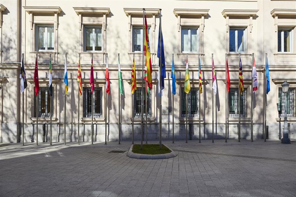 Archivo - Banderas de las comunidades autónomas frente a la fachada del Palacio del Senado, en Madrid (España).