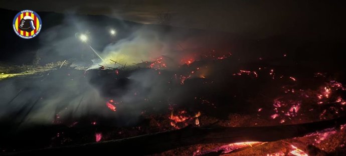 Extinguen un incendio de restos de vegetación arrastrada por la dana en el río Magro en Llombai (Valencia).