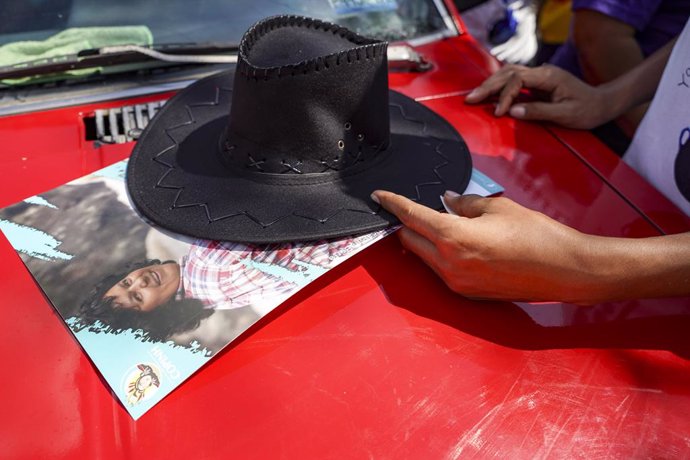 Archivo - March 22, 2022, San Salvador, El Salvador: A protester places his hat on a sign of assassinated environmental activist Berta CÂ·ceres, killed in Honduras in 2016, during a protest for the recognition of water as a human right in San Salvador. Pr